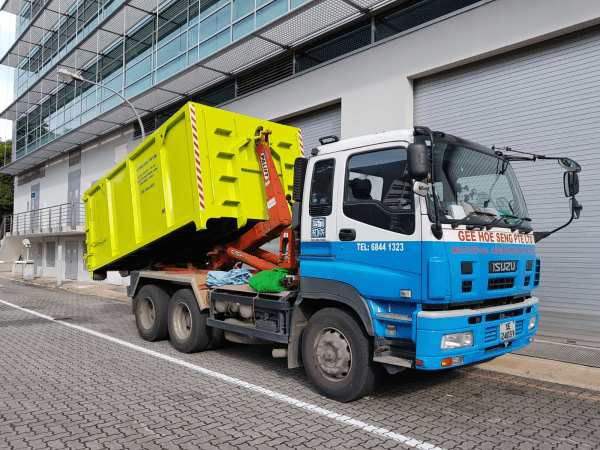 Hooklift Truck for Waste Collection and OTC Transport Hooklift truck loading open top container (OTC) at industrial site in Singapore