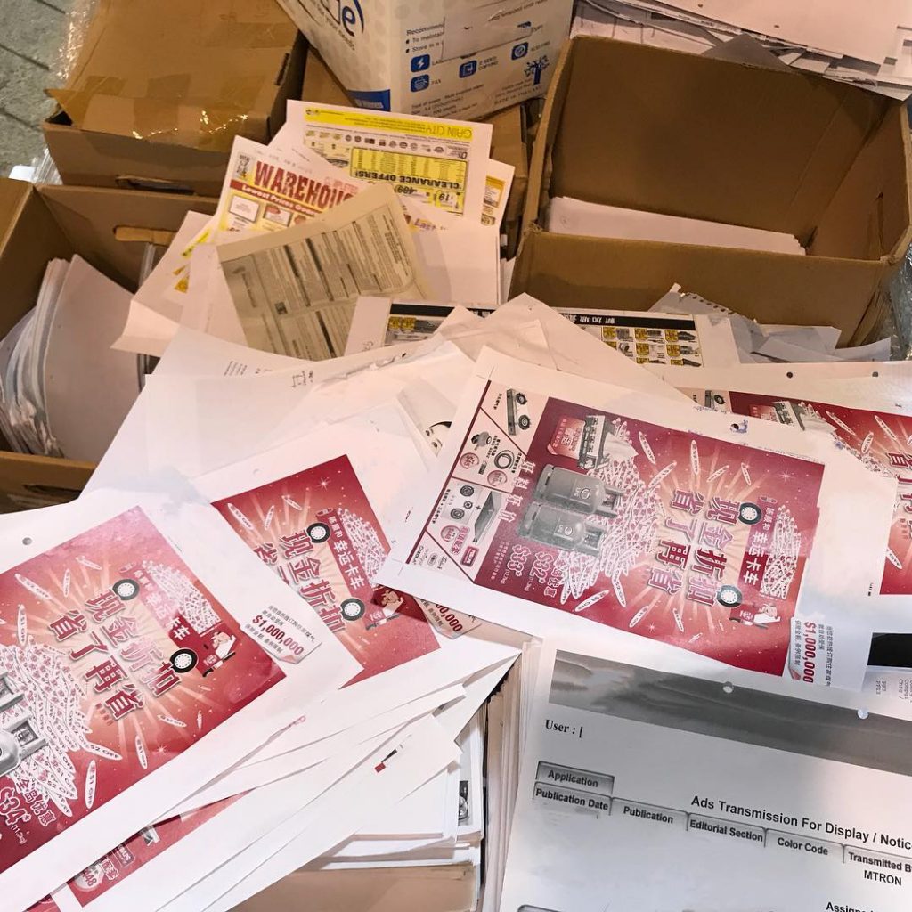 Collected colour printed papers and marketing materials prepared for recycling in Singapore.