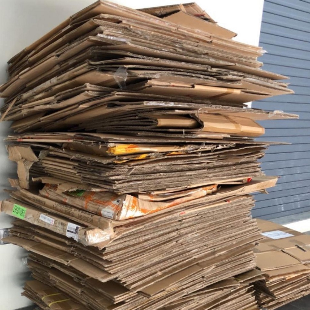 Stack of flattened carton boxes prepared for recycling in Singapore.