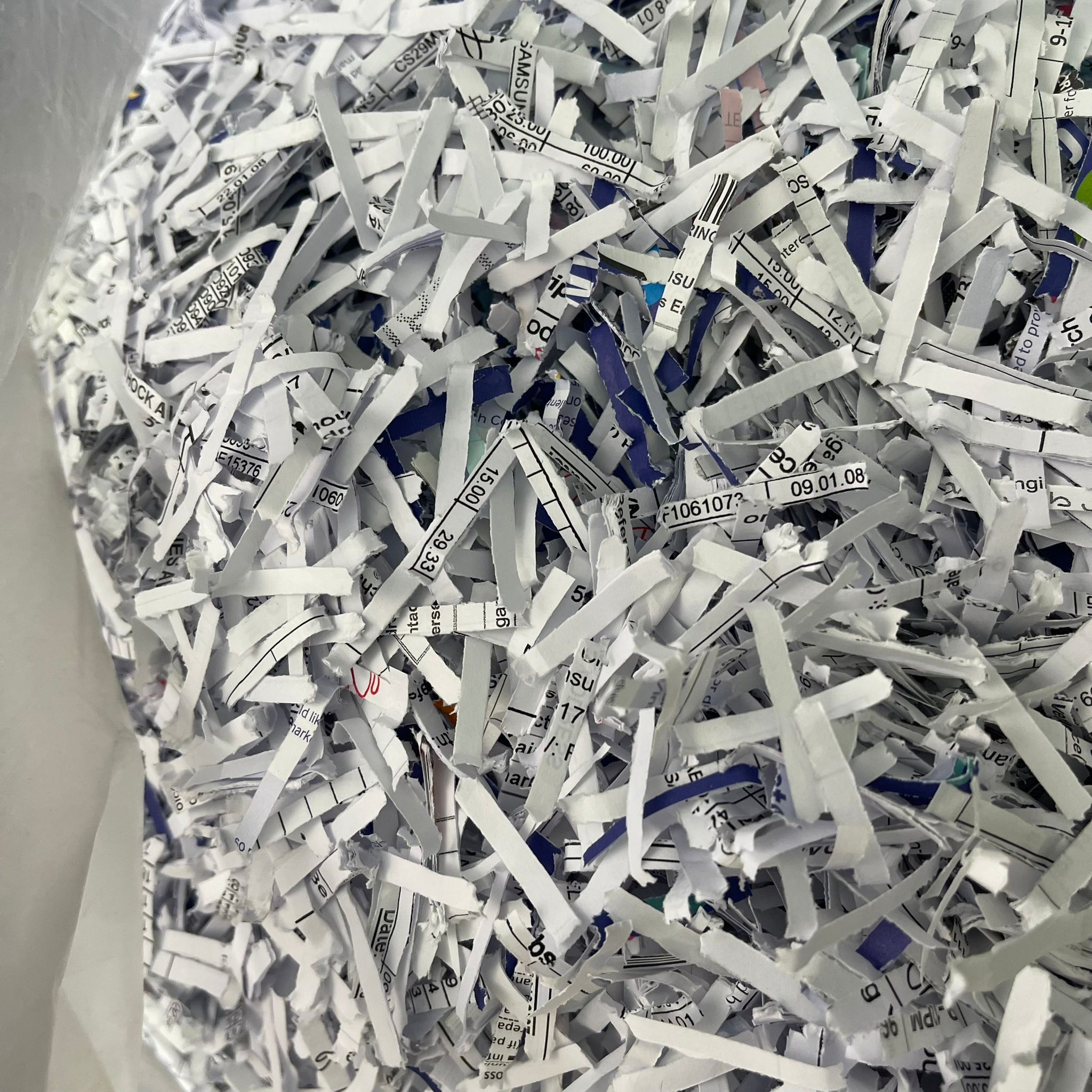 Shredded office paper collected in a bag for recycling in Singapore.
